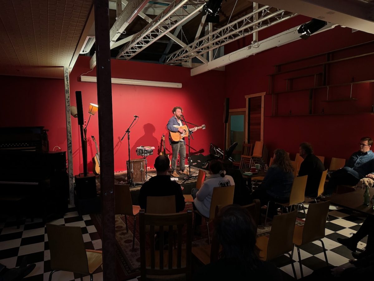 Person plays guitar on stage.