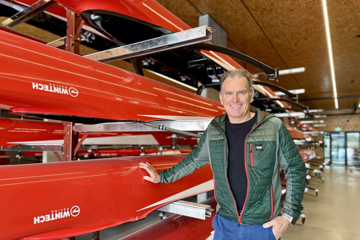 man standing in a rowing shed