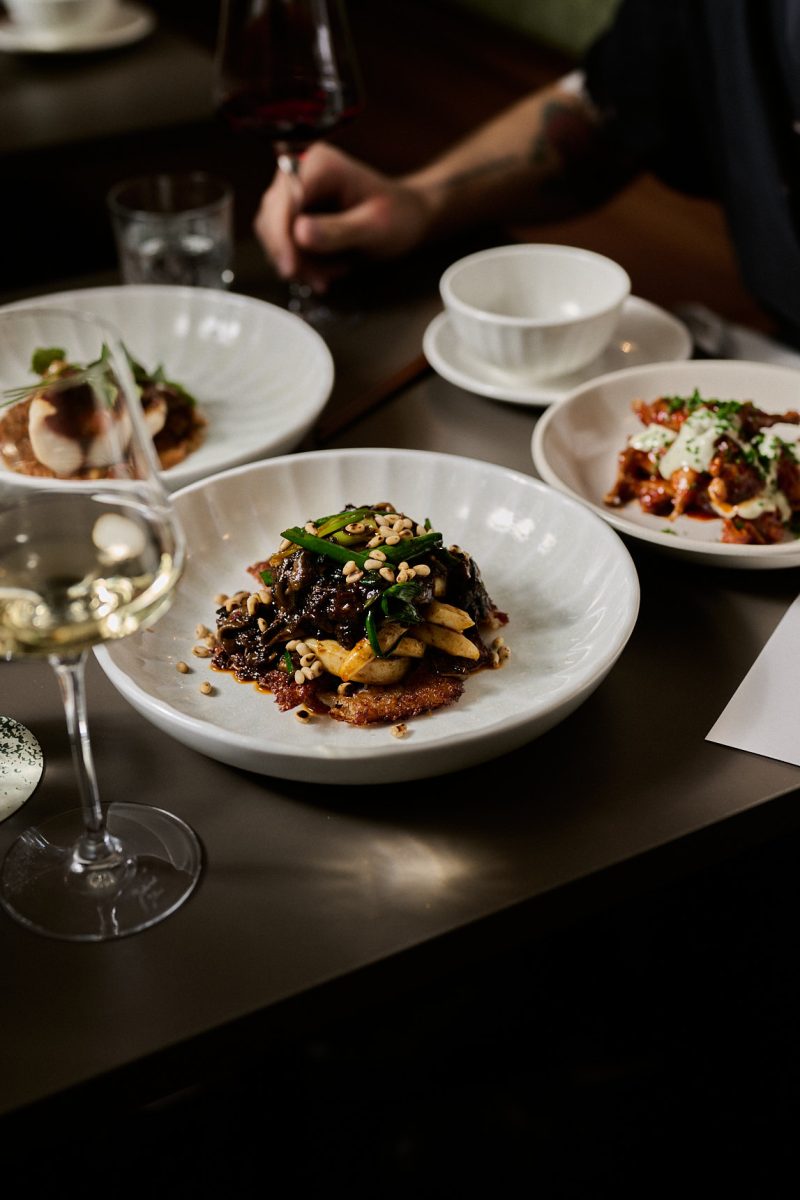 Fine dining dishes on a table with glasses of wine.