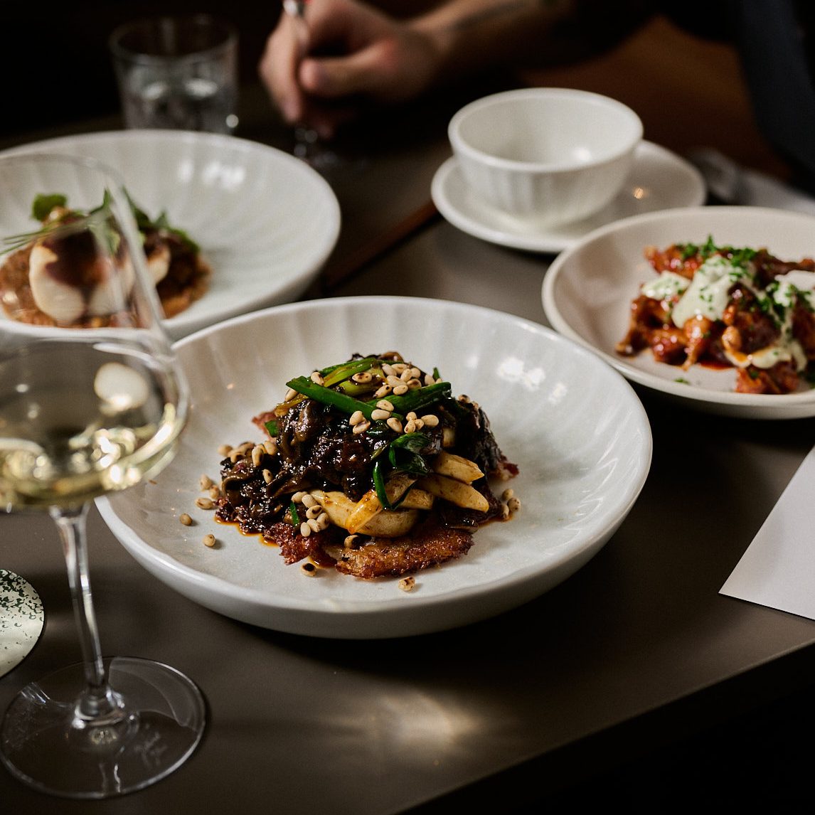 Delicious dishes on a table with glasses of wine.