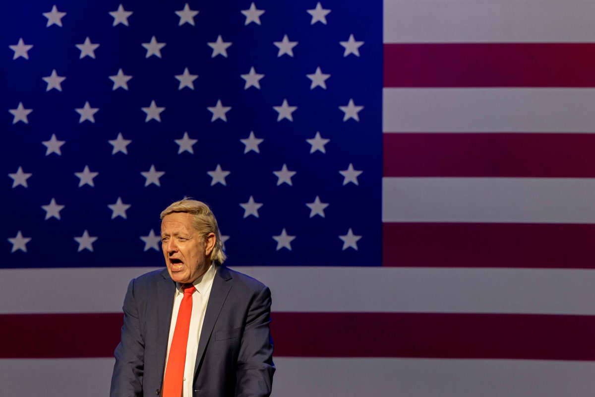 man standing in front of flag