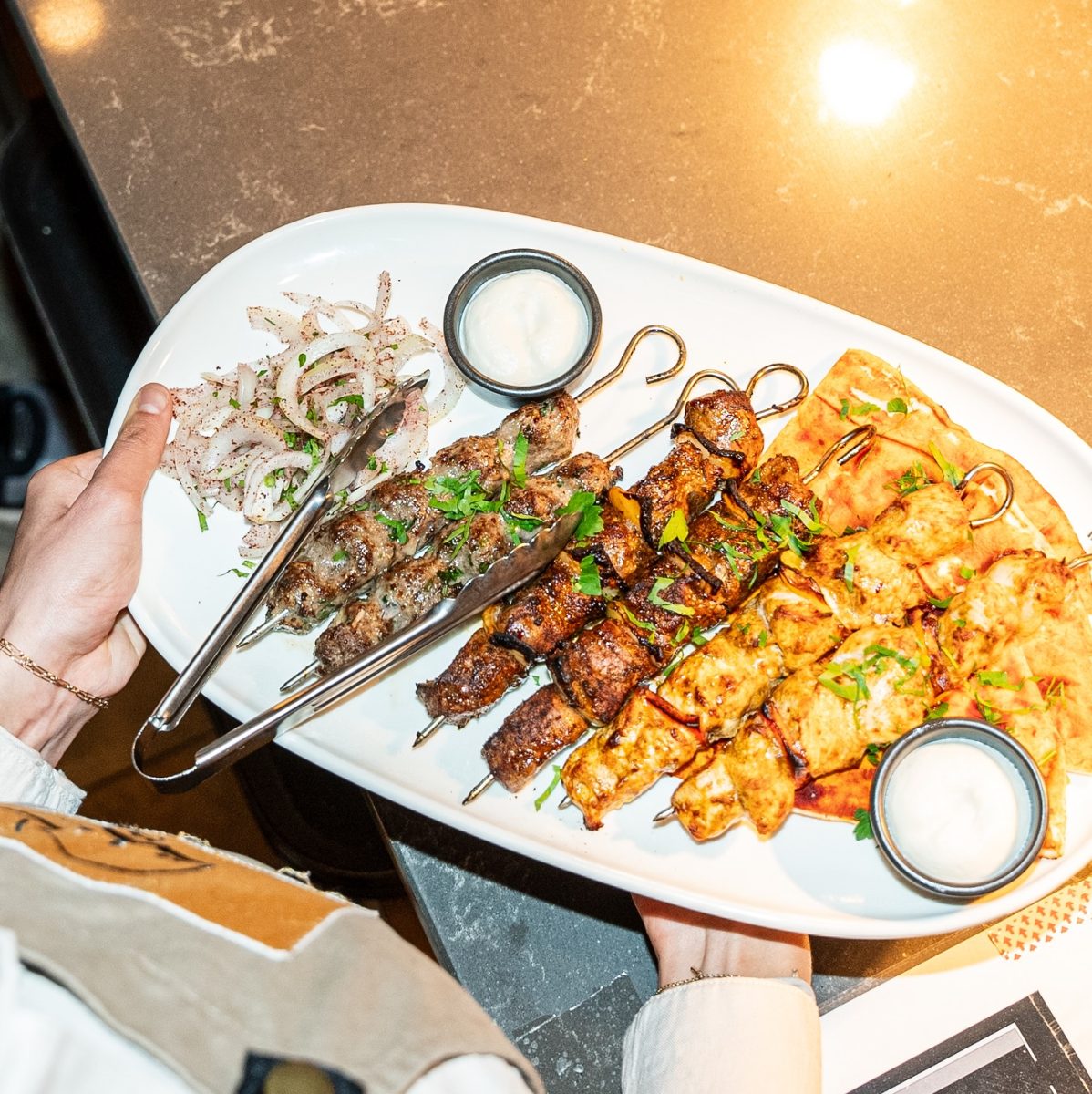 An above shot of a platter of grilled meat skewers