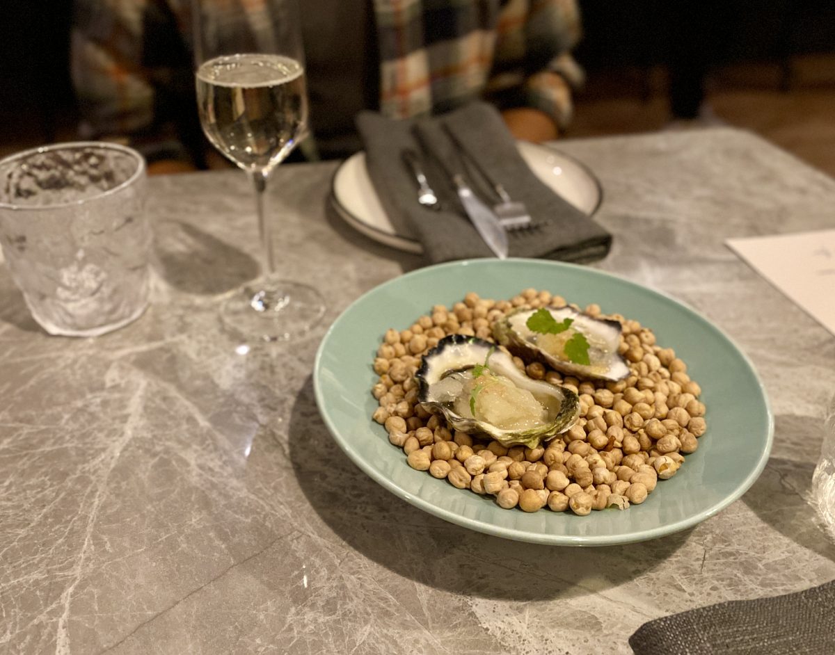 Two oysters served on a bed of chickpeas.