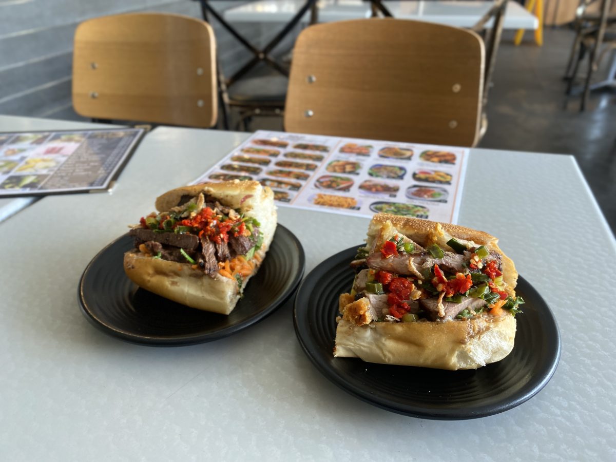 Two half banh mi buns on a restaurant table.