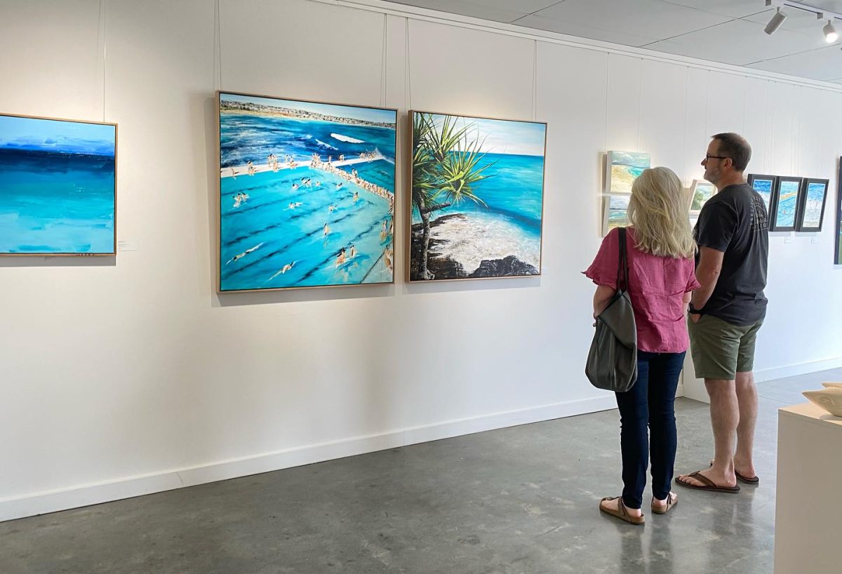 man and woman viewing gallery artwork