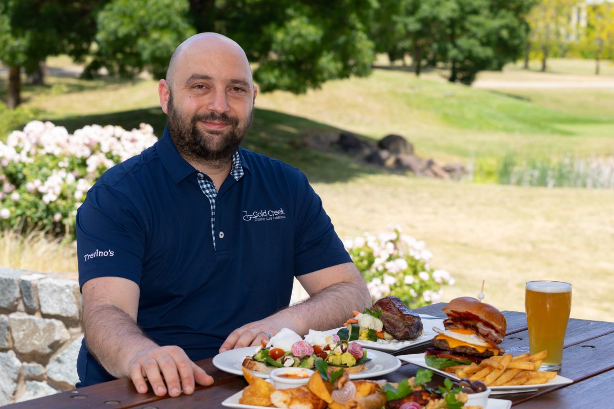 Man sitting in front of plates of food and looking at camera