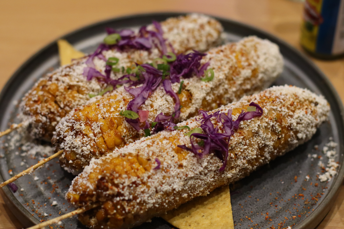 A row of three corn on the cob, Elotes.