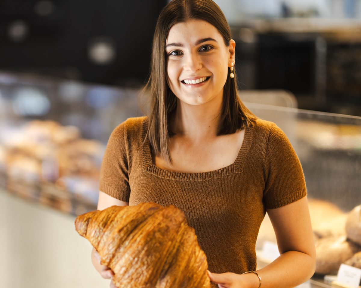 Three Mills Bakery's 2024 Chief Croissant Consumption Officer Mel Myrteza holding a croissant