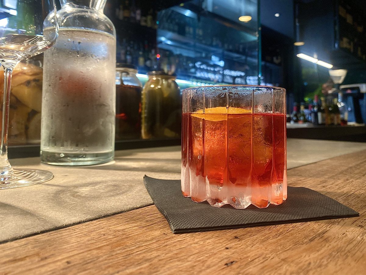 A Negroni on a wooden bar.