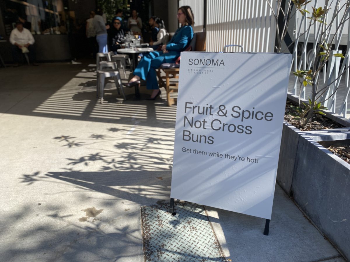 An A-frame sign reading Fruit & Spice, Not Cross Buns.