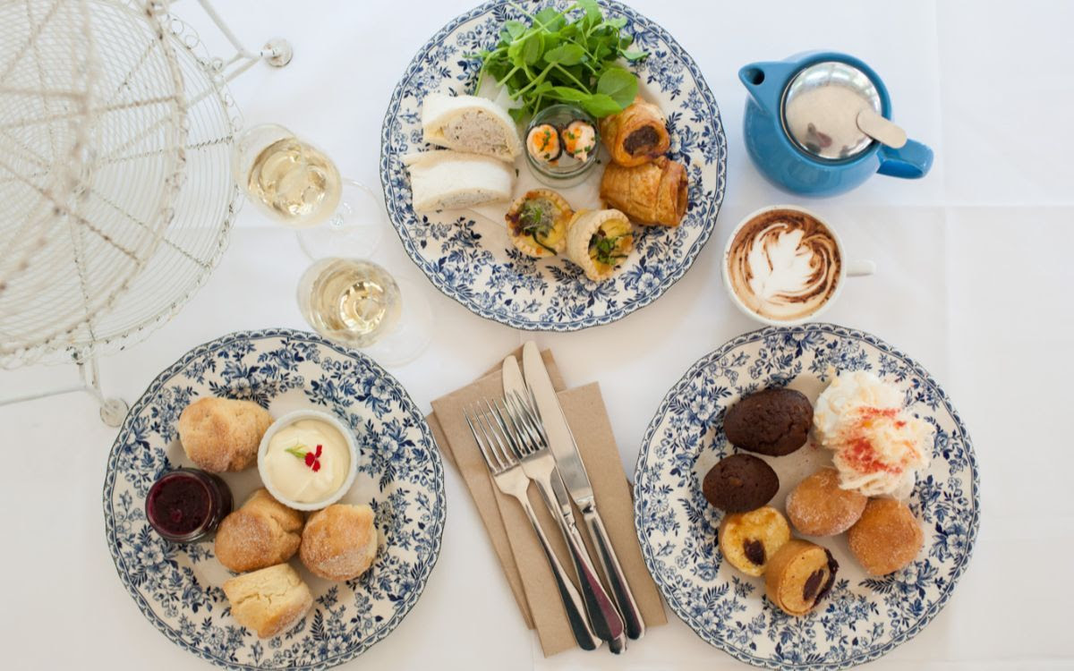 plates of finger food on a table with cutlery and drinks