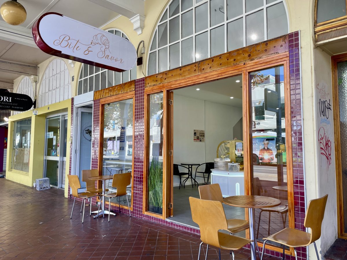 Bite and Savor signage (featuring line-drawn croissant) and their shopfront with red tiles.