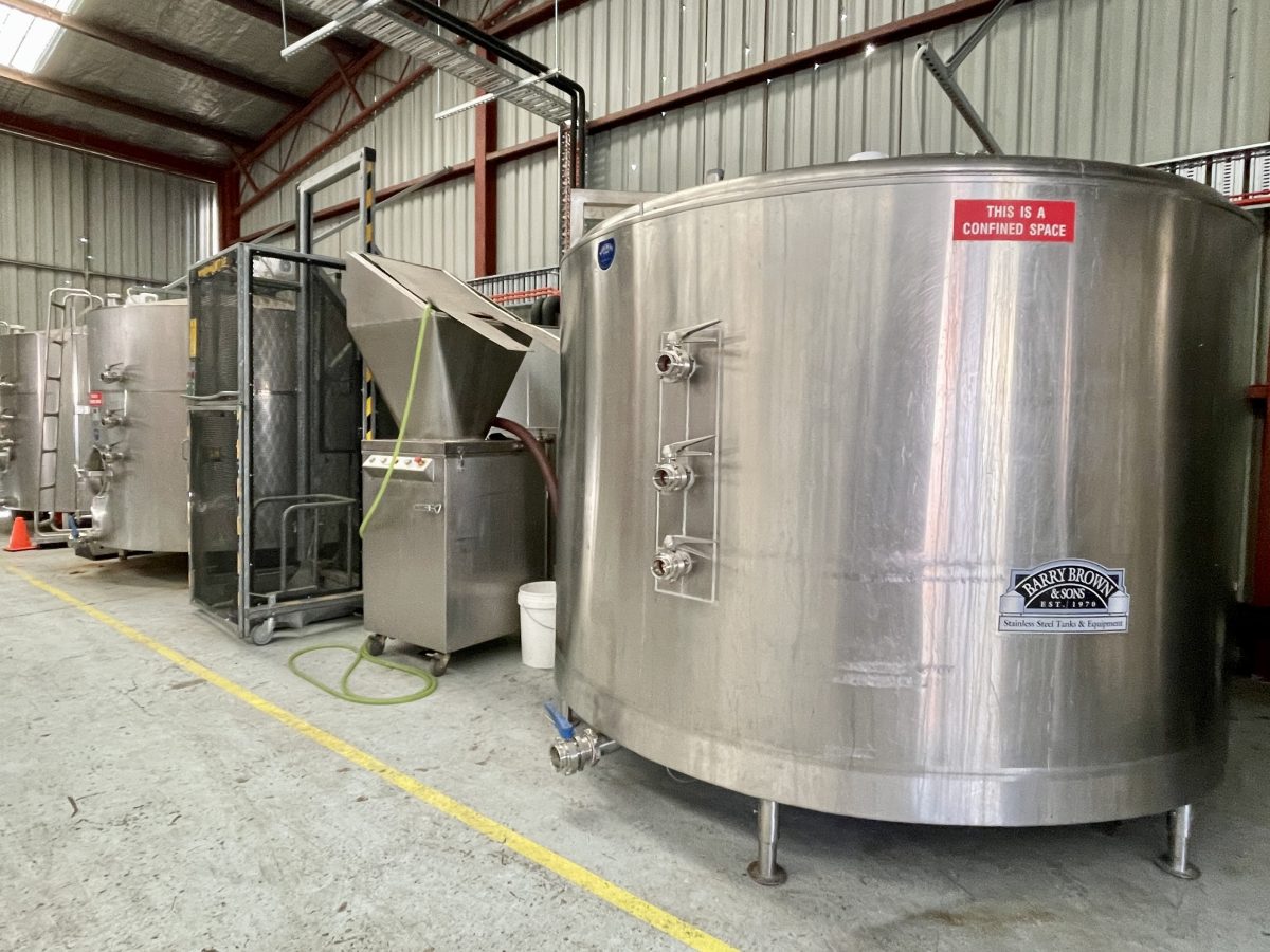 Large stainless steel fermenter in a factory.