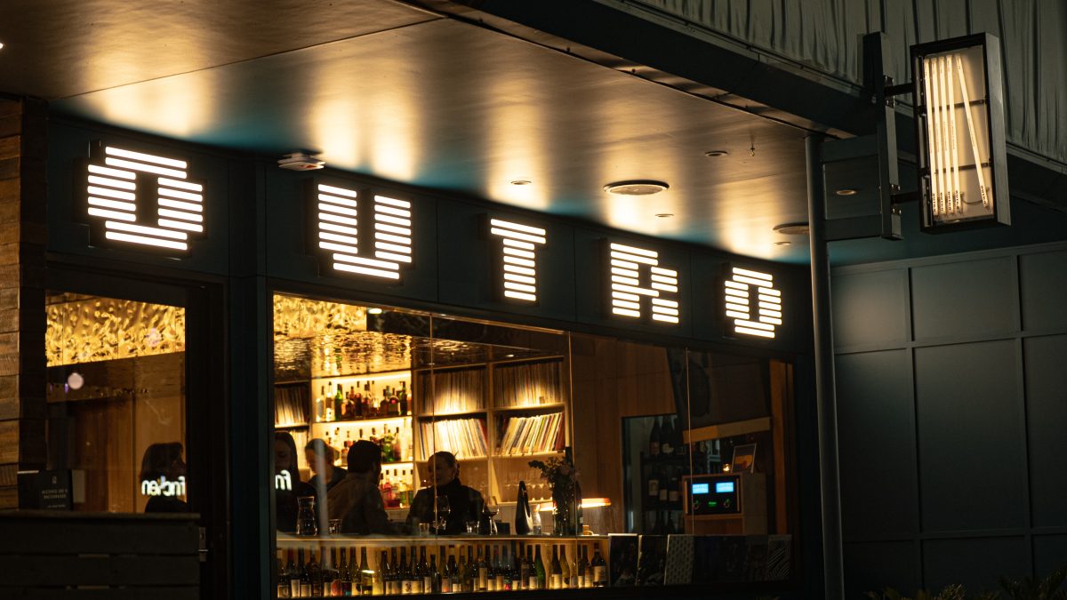 Exterior of Bar reading OUTRO in retro looking lights.