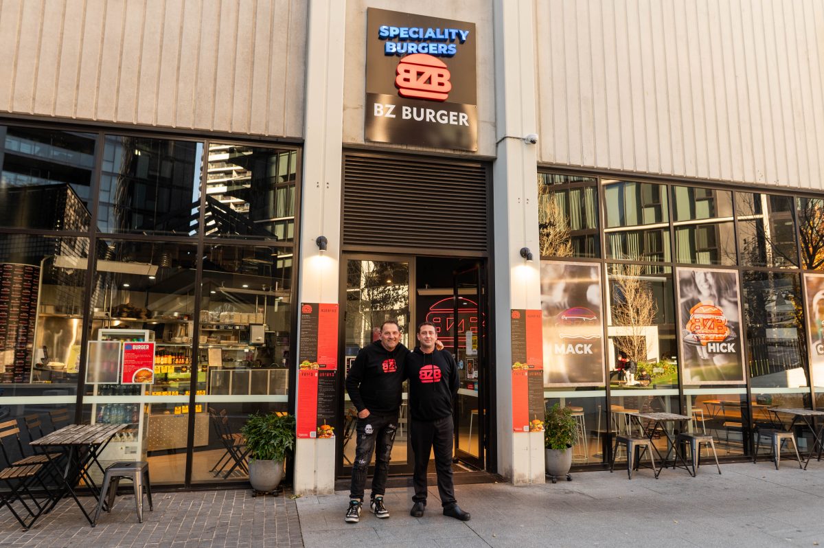 two men stand outisde a burger joint