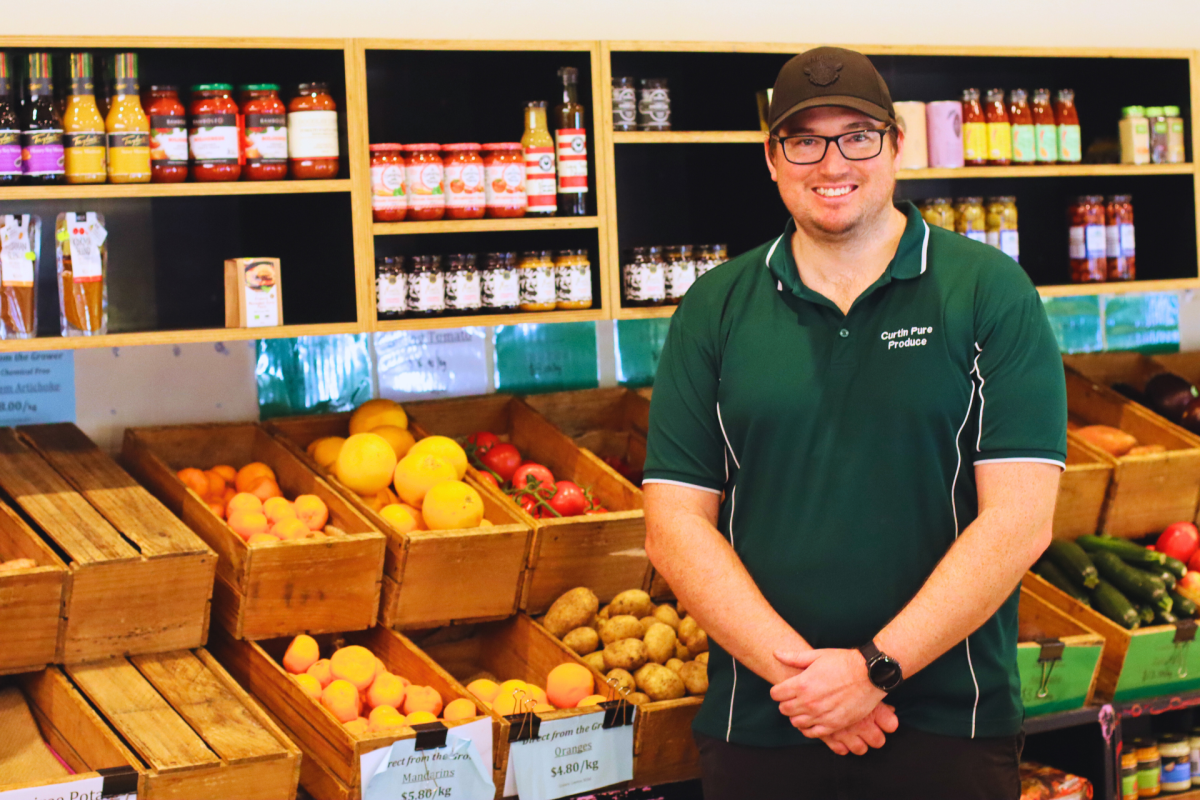Man stands in front of grocery display.