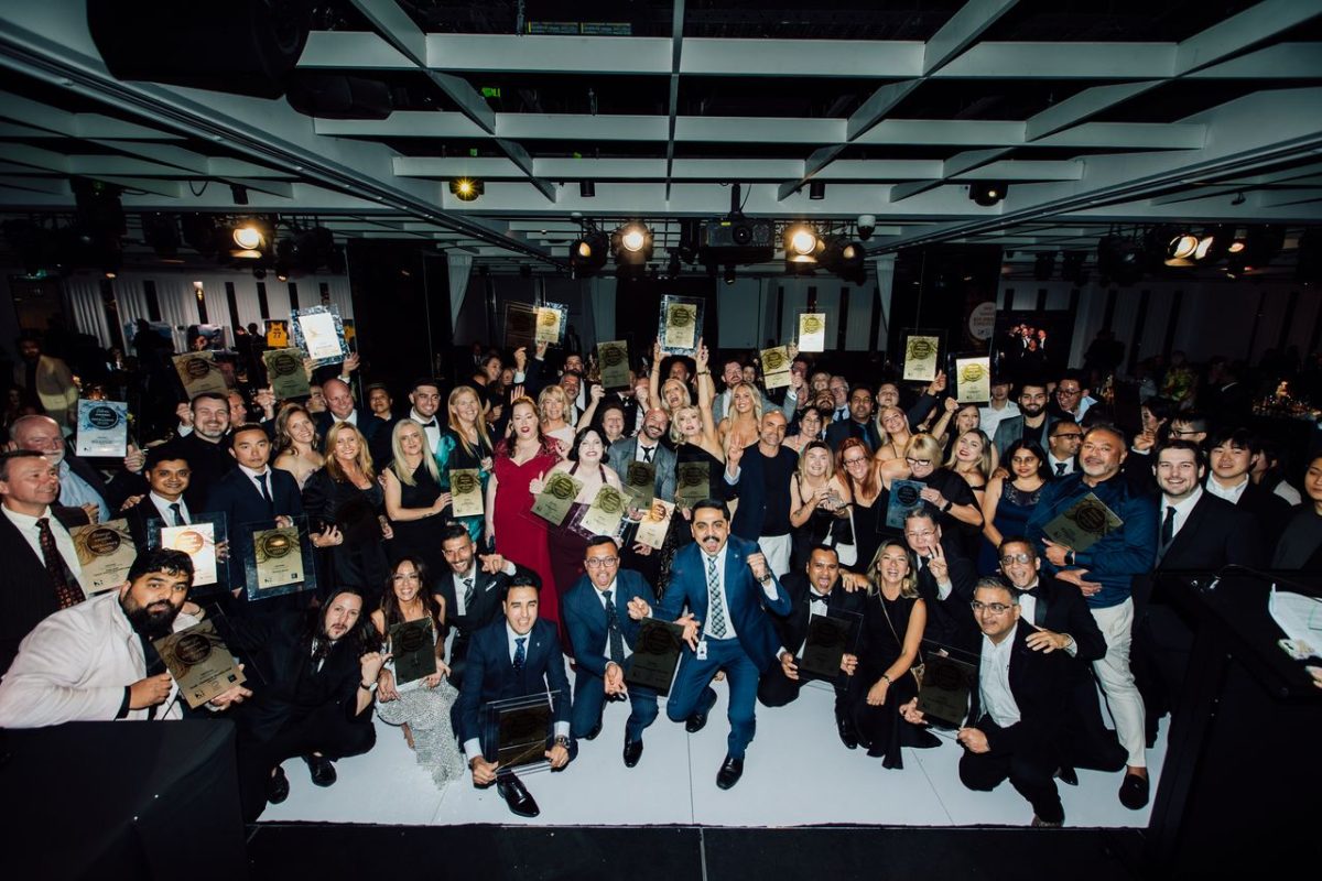 Group photo of people smiling and holding their trophies. 