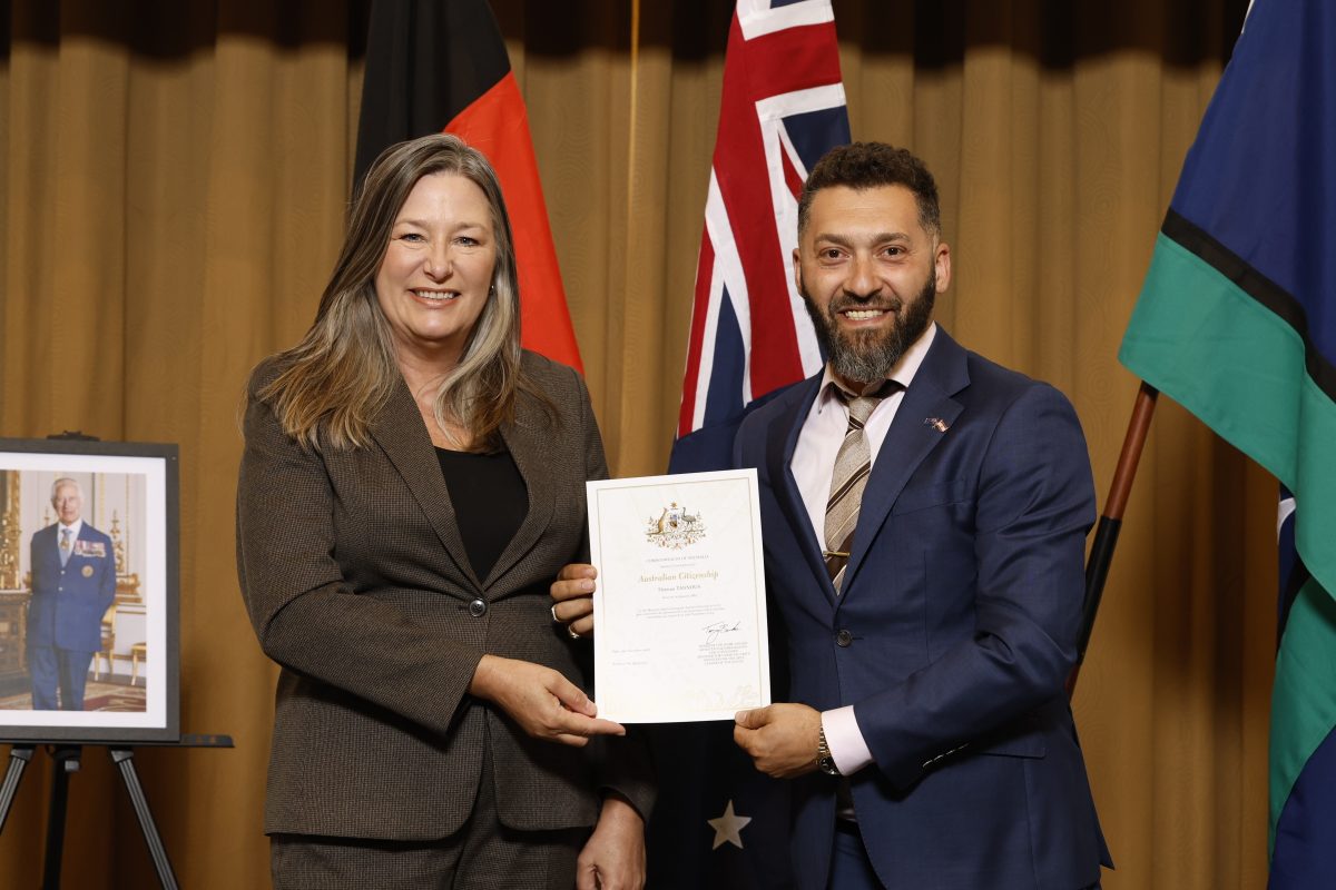 Man and woman hold certificate and smile at camera.