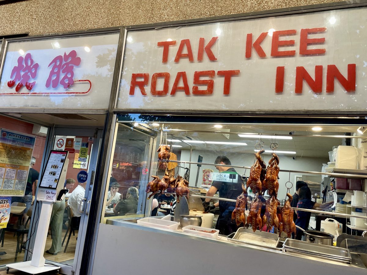 Bold red letters spell 'Tak Kee Roast Inn' with Chinese characters to the left. Underneath, a window displays roast ducks. 