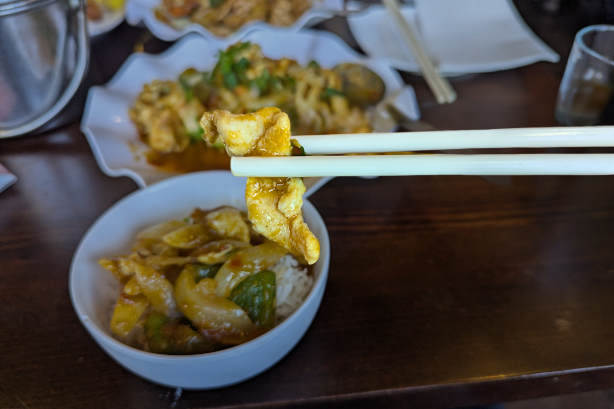 Chicken being held with chopsticks.