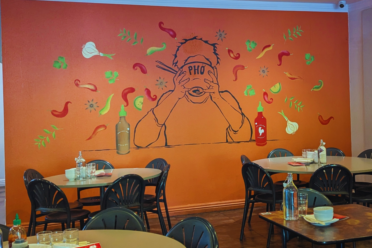 Mural on wall with person drinking from soup bowl.