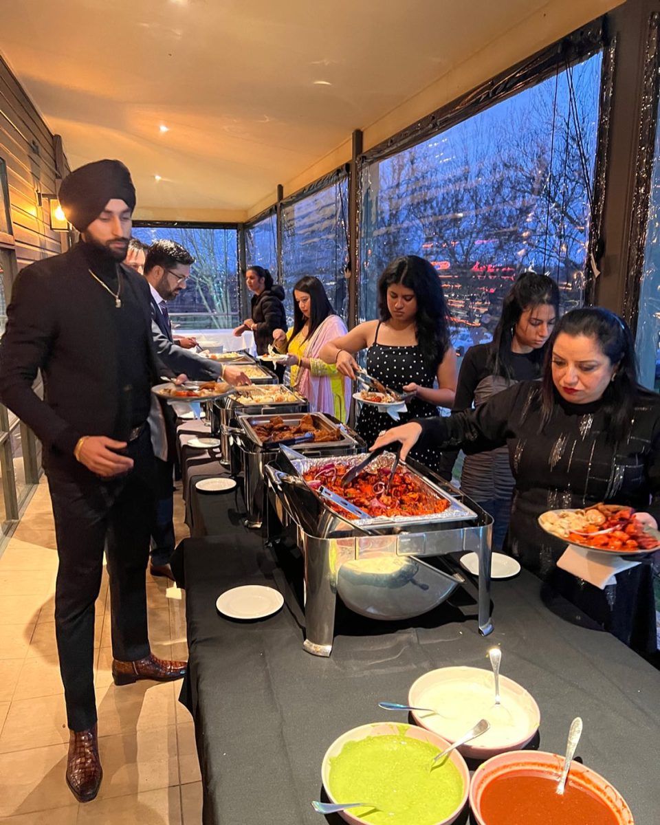 A man in a turban serving guests at a buffet