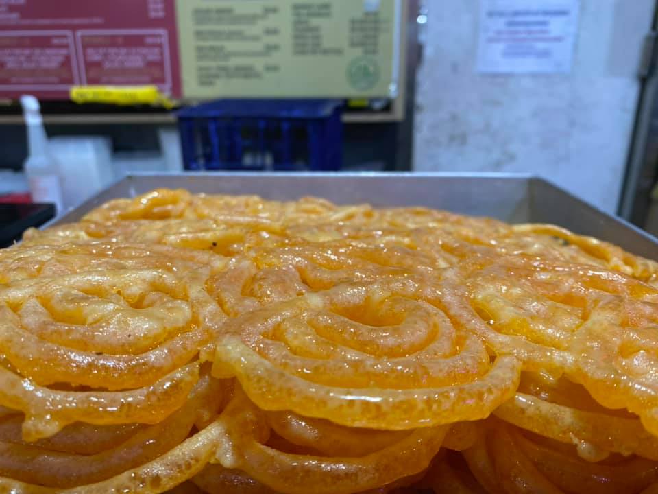 Close-up of ''jabeli'' sweets: tight orange coils of dough fried and doused in sugar syrup
