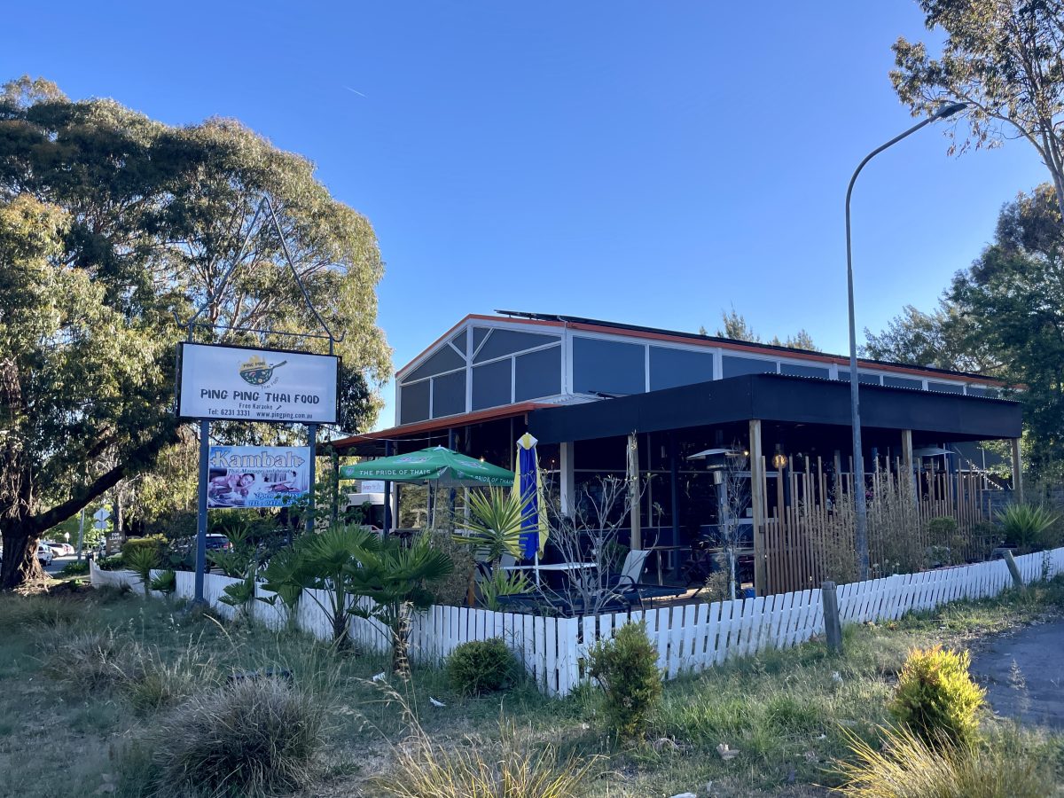 A two story building with outdoor dining area and signs reading Ping Ping Thai, and Kambah Thai Massage.