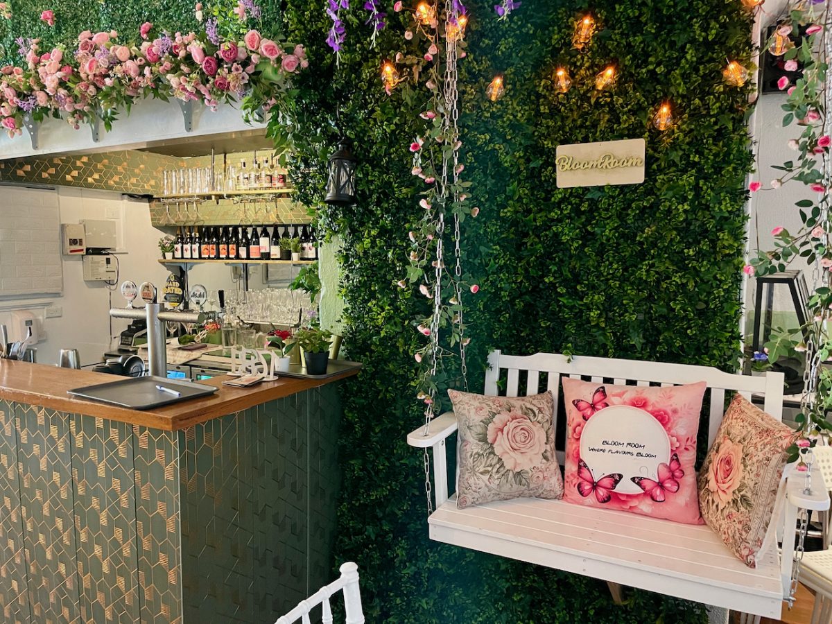 A white swing seat next to a bar.