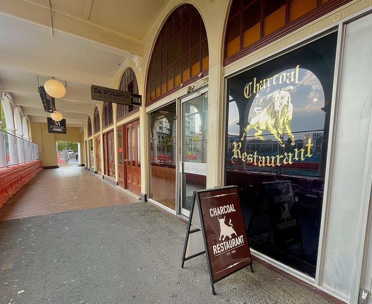 The exterior of Charcoal Restaurant, with a gold bull on the window.