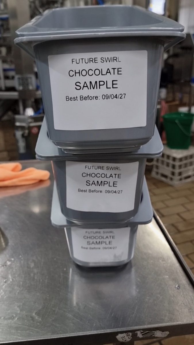 Three grey plastic ice cream tubs stacked up, with 'Future Swirl sample' on each, and details of flavour and use by date.