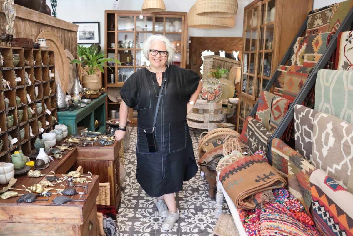 Margot stands in shop.